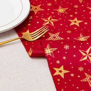 Detailed view of red velvet table runner with gold foil stars and snowflakes texture