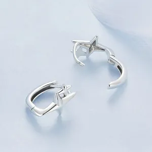 Minimalist S925 sterling silver star huggie earrings for women on soft blue background