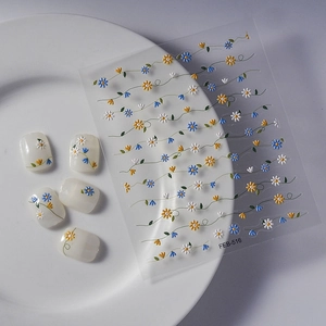 Detail view of daisy embossed nail art stickers with blue and yellow flower patterns