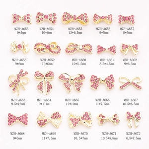 20 styles of golden alloy bow nail charms with pink rhinestones and size details