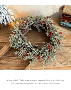 Detail of Christmas wreath with red berries and pine cones on a rustic wooden background