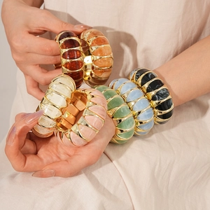 Detail of vintage colorful resin bangles with gold metal layers on model wrist