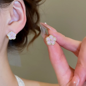 Macro detail of a pink flower stud earring with gold plating and cubic zirconia