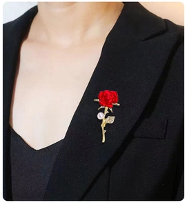 Close-up of red rose brooch with pearls and crystals on a black suit lapel