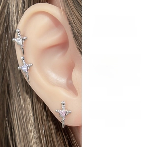 Macro detail of silver dagger earrings featuring heart-shaped zircon inlays