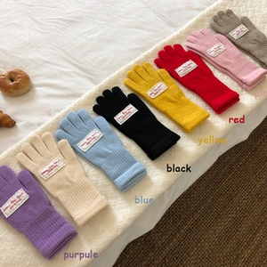 Primer plano de guantes táctiles de punto multicolor en rosa, rojo, azul y amarillo