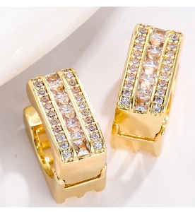 Macro shot of gold rectangular huggie hoop earrings with micro-pave sparkling cubic zirconia