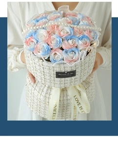 Close-up of pink and blue soap roses in a tweed box with pearl handle and ribbons