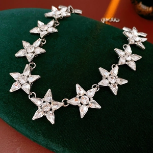 Macro di una collana di stelle con cristalli su velluto verde con luci calde e soffuse