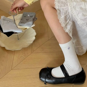 Détail de la texture en maille avec nœud décoratif sur chaussettes blanches en coton