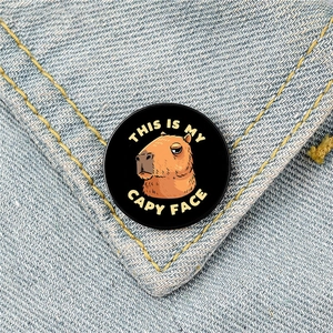 Funny Capybara enamel pin with 'THIS IS MY CAPY FACE' text on blue denim jacket