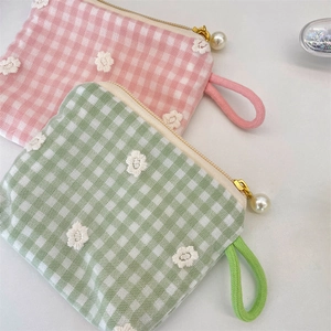 Detail of floral lace embroidery and pearl zipper pull on fabric coin purses