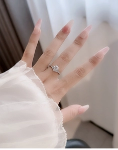 Close-up of 925 silver moissanite crown ring set and V-shaped band on woman hand