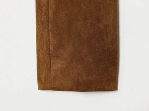 Detail of dark brown suede fabric with precision stitching on a women's short jacket