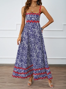 Detail of blue printed sundress featuring distinctive red zigzag trim and waist accent