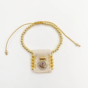 Detail of hand-woven St. Benedict medal on a golden bead adjustable religious bracelet