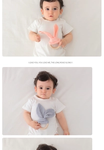 Detail of baby wood ring teething toy with cotton rabbit ears in pink and grey colors