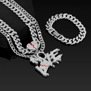 Close-up of iced out Cuban link chain set with NO LOVE melting pendant and red accents