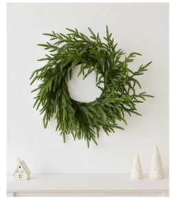 Close-up of artificial Norfolk Pine wreath with realistic green branches for Christmas decor