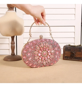 Detail of pink rhinestone evening clutch with crystal flower and gold ring handle