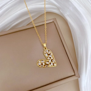 Macro shot of gold heart pendant with inlaid crystals on elegant silk fabric background