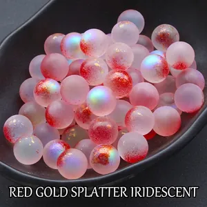 Close-up of 12mm frosted red iridescent glass beads with gold foil in a tray