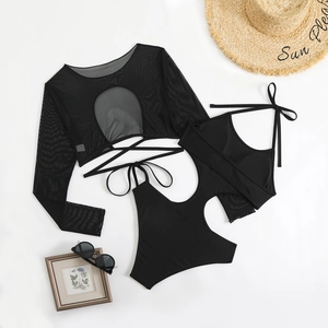 Flat lay of black three-piece swimwear set with mesh cover-up and stylish accessories