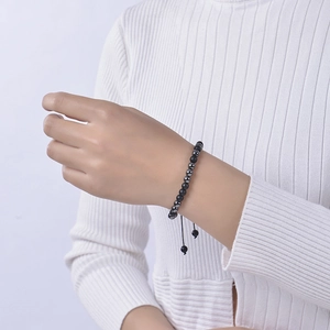 Close-up of Morse code beaded bracelet with matte black stones and adjustable cord on wrist