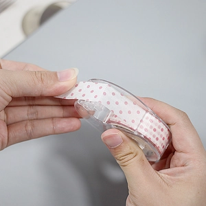 Portable washi tape cutter with pink polka dot decorative tape for DIY journaling