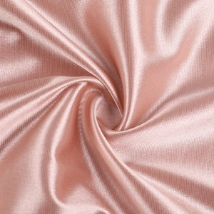 Detail of pink satin fabric showing high gloss texture and soft elegant silk drapes