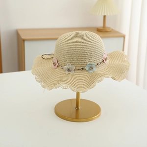 Détail du chapeau de paille pour enfants avec fleurs 3D colorées et bord ondulé anti-soleil