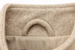 Dettaglio del colletto della giacca bomber beige con texture lana e asola interna