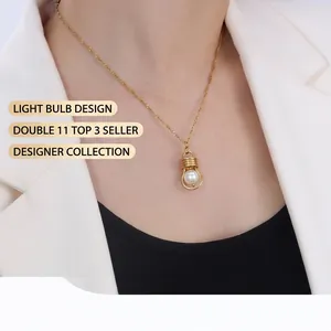 Detail of creative gold lightbulb pendant with white pearl on 18k gold chain necklace
