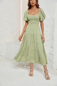 Détail de la robe longue étagée vert clair avec manches bouffantes et buste froncé