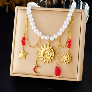 Detail of vintage gold sun and moon pendants on a pearl chain necklace display
