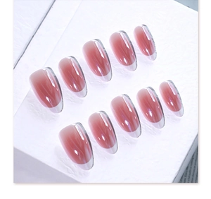 Macro detail of almond shaped press-on nails with pink ombre and pearlescent gloss finish