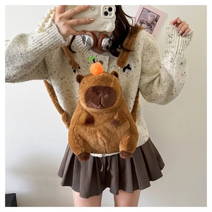 Close-up of cute brown plush capybara backpack with orange fruit detail on model