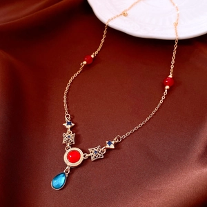 Close-up of vintage resin necklace with red and blue teardrop charms on brown silk