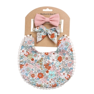 Baby-Lätzchen und Stirnband-Set mit rosa und floralen Drucken auf einer Karte