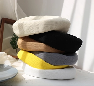 Close-up of assorted colorful knitted berets showing thick texture and soft material