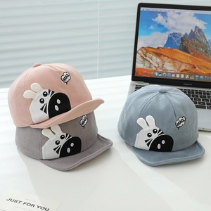 Detail of baby corduroy baseball caps featuring cute cartoon patches in three soft colors