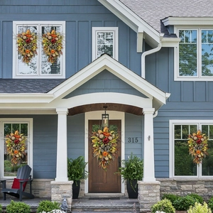 Symmetric fall wreaths with leopard print ornaments on a blue house exterior