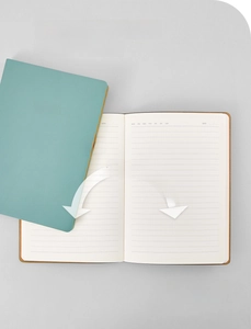 Detailed view of A6 notebook with teal cover and 180 degree flat lay ruled pages