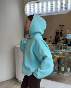 Detail of light blue oversized hoodie with heavy cotton texture and drop shoulder design