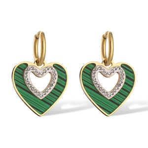 Macro shot of gold hoop earrings featuring green malachite heart pendants and crystal inlay