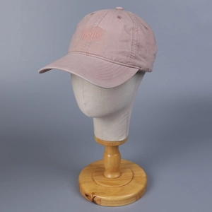 Detalle de gorra de béisbol rosa en algodón lavado con bordado hello y visera curva