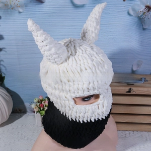 Close-up of black and white knit devil horn balaclava with warm thick yarn texture