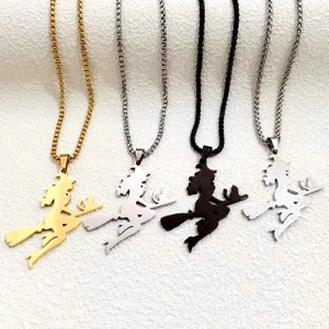 Macro view of witch on broomstick necklaces in gold, silver, black and matte finishes