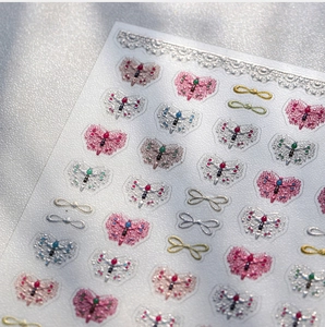 Detail of 3D embossed butterfly nail stickers with metallic edges and glitter finish