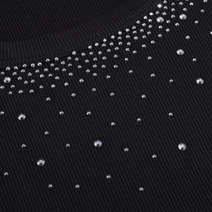 Close-up of sparkling silver rhinestones on black ribbed knit square neck dress